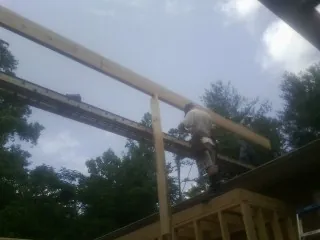 Carpenter setting a ridge beam over a new addition frame — Ice Dam Removal by Roofing Brothers in Brasstown