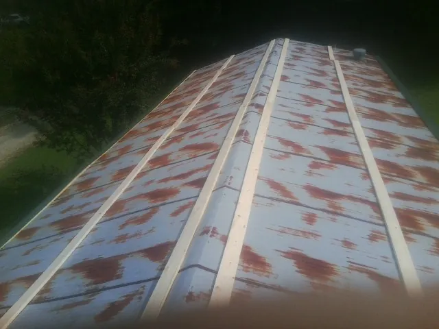 Rusted metal roof panels with new wood purlins before replacement — Storm Damage Roof Repair in Brasstown by Roofing Brothers