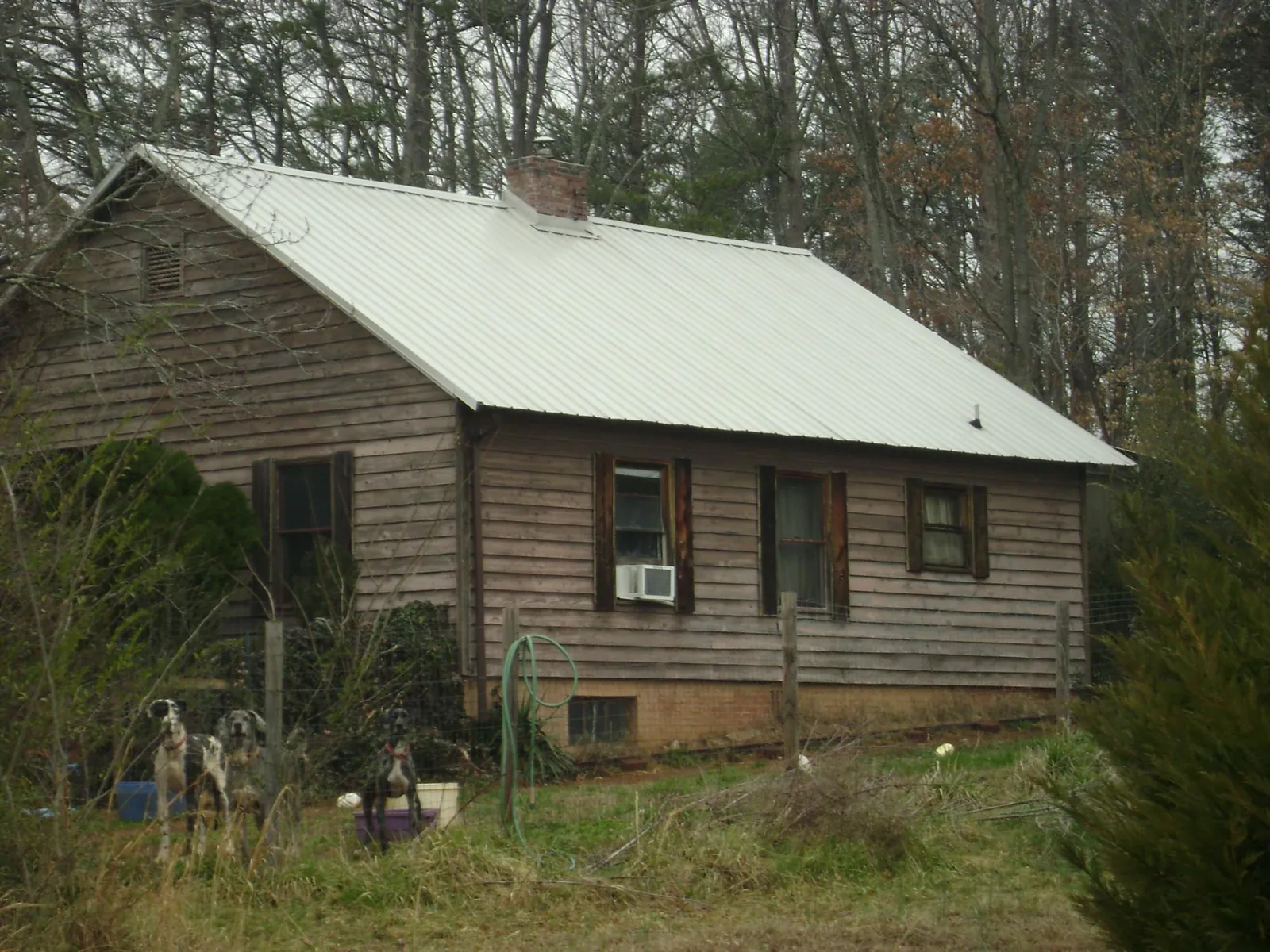 White metal roof on an old wood sided farmhouse, from a Metal Roof Installation job in Brasstown